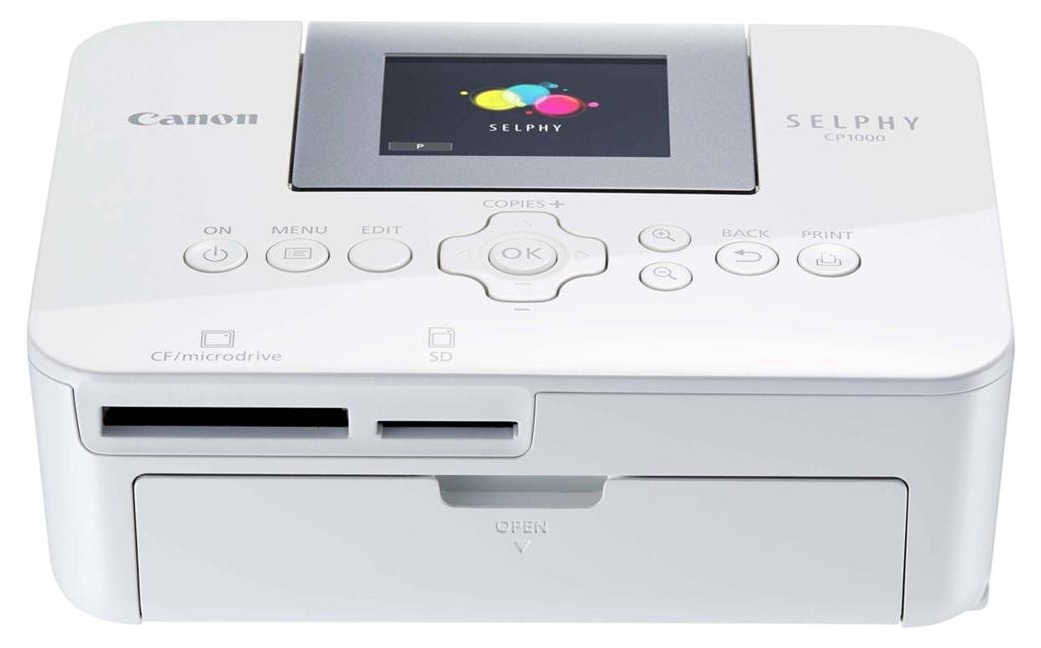 Impresora Fotográfica / Canon CP1000 | 2607 – Canon SELPHY CP1000 es una impresora compacta diseñada para imprimir fotografías de alta calidad mediante sublimación térmica. Resolución: 300 × 300 dpi, Profundidad de color: 16.8 millones de colores